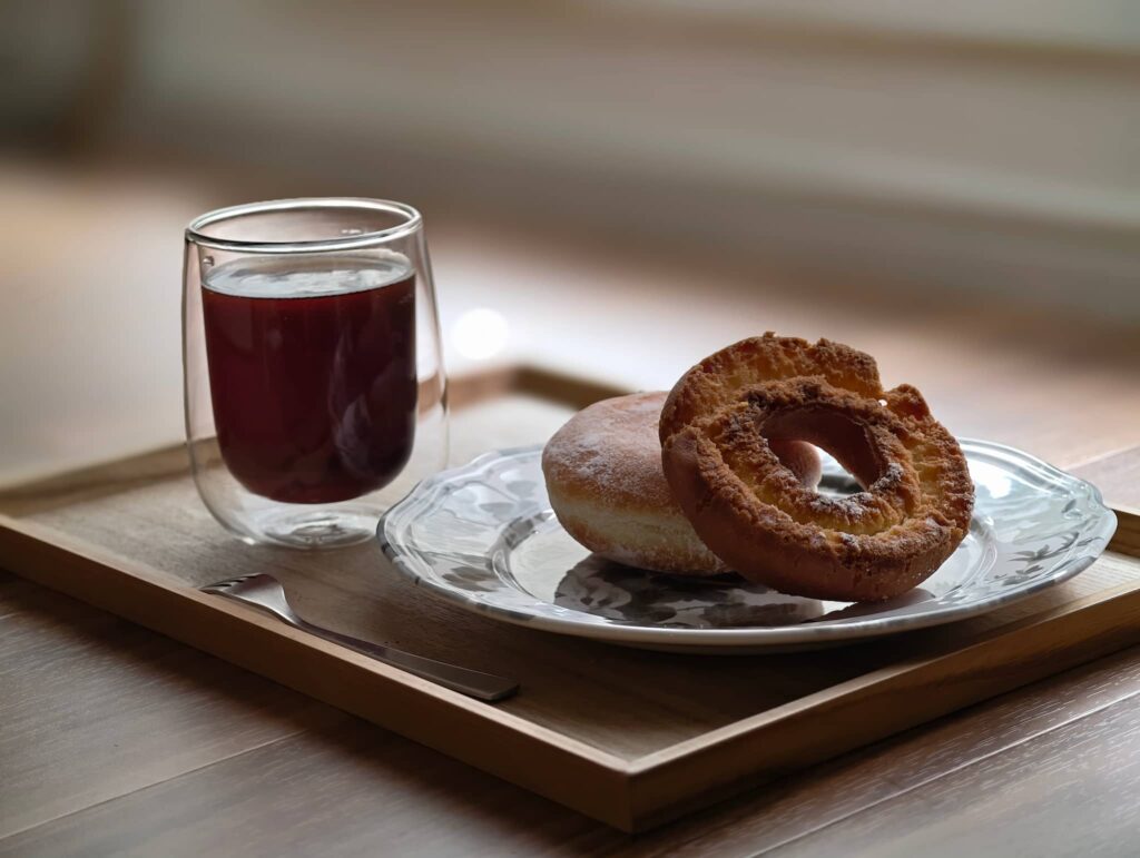 スマホカメラで撮影した、窓際に置かれたコーヒーとドーナツ